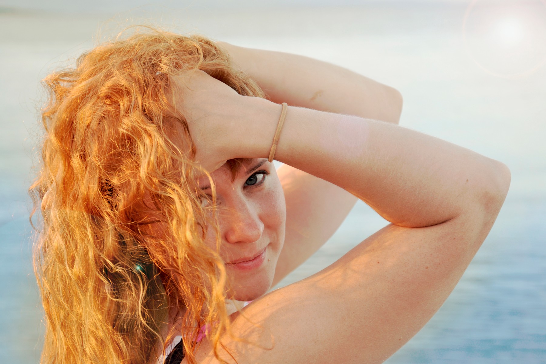 Frau mit roten Haaren streicht sich durch die Haare